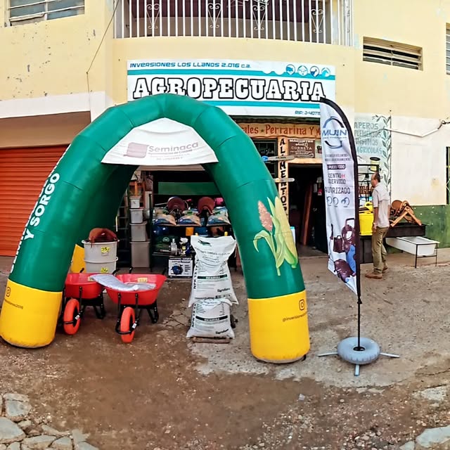 Fachada de Agropecuaria Los Llanos 2016 en Valle de la Pascua, con el rótulo, carretillas y una carpa de Seminaca